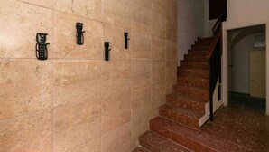 A staircase with a handrail and a wall-mounted light fixture.