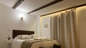 A bedroom with a bed, bedside table, and a bench.