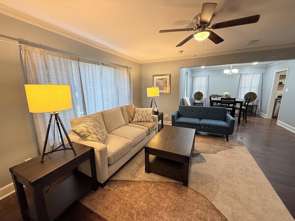 Ein Wohnzimmer mit Sofa, Couchtisch, Lampe und Deckenventilator.