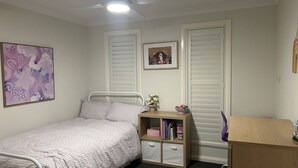 A bedroom with a single bed, a bedside table with books, a small shelf with a vase, and a framed picture on the wall. - Lap of Luxury- Bathurst House
Very generous floor plan with dual living areas (Kelso)