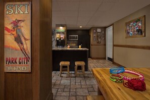 Ein Barbereich im Ski-Design mit Hockstühlen und einer Theke, einschließlich eines Skisportposters.