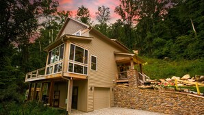 A two-story house with a balcony, a stone wall, and a garage.
