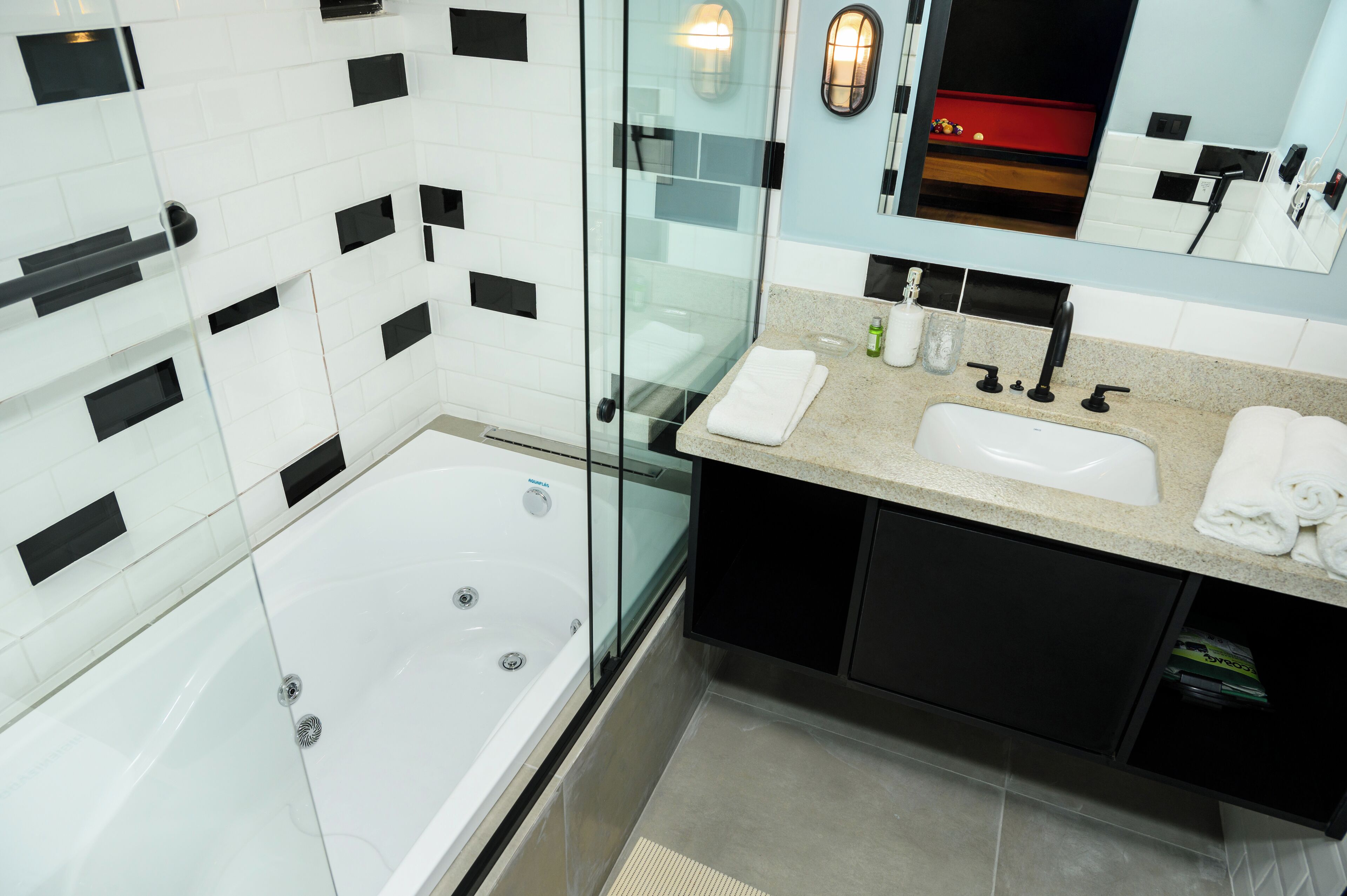 A modern bathroom with a glass-enclosed bathtub, a vanity with a sink, and a mirror above the mirror cabinet.