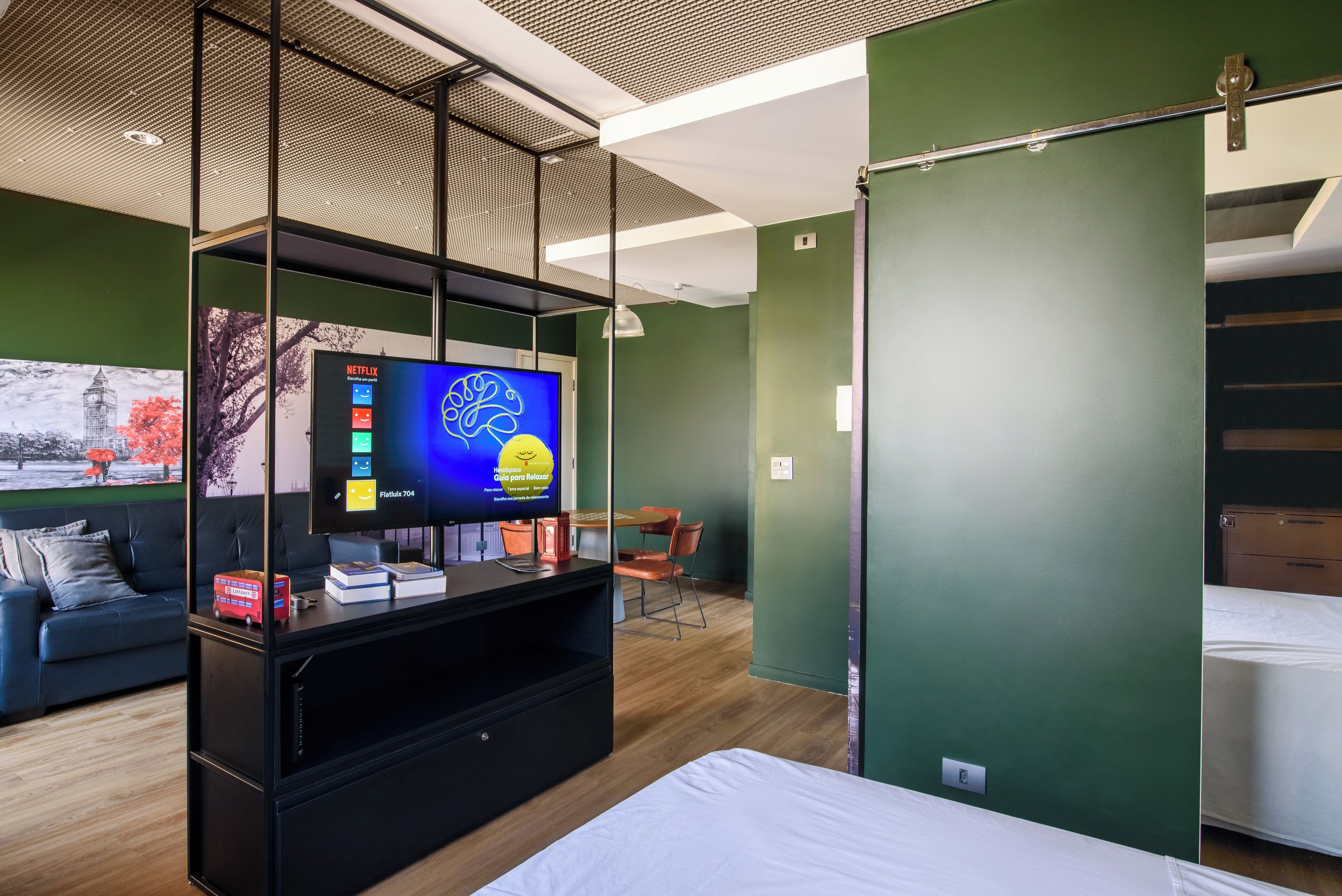 Une chambre d’hôtel moderne équipée d’une télévision à écran plat, d’un canapé, d’une table à manger et d’un lit.