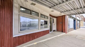 A building facade with large windows, a covered entrance, and a metal roof. - The Loft small studio apartment on the 2nd floor.  Private, Small & Affordable (Albert Lea)