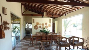 A spacious dining area with a checkered floor, wooden furniture, and a ceiling with exposed beams.