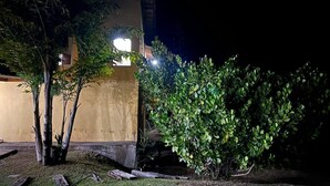 A nighttime view of a building with a yellow facade and a well-lit entrance.