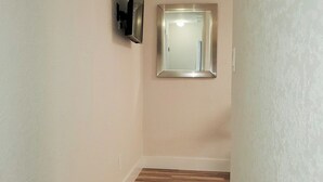 A hallway with a wooden floor, a wall-mounted TV, and a mirror. - Dania Beach 1BR Retreat - Private Entry & Self Check-In (Dania Beach)