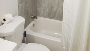 A bathroom with a bathtub, toilet, and shower. - Dania Beach 1BR Retreat - Private Entry & Self Check-In (Dania Beach)
