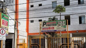 Un edificio con un letrero que dice 'Pousada Freitas' y una entrada con portones.