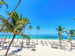 On the beach, white sand, sun-loungers, beach umbrellas