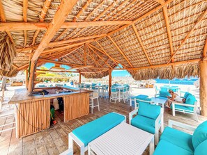 Zona exterior amb taules i caires, un bar i vista a l'oceà.