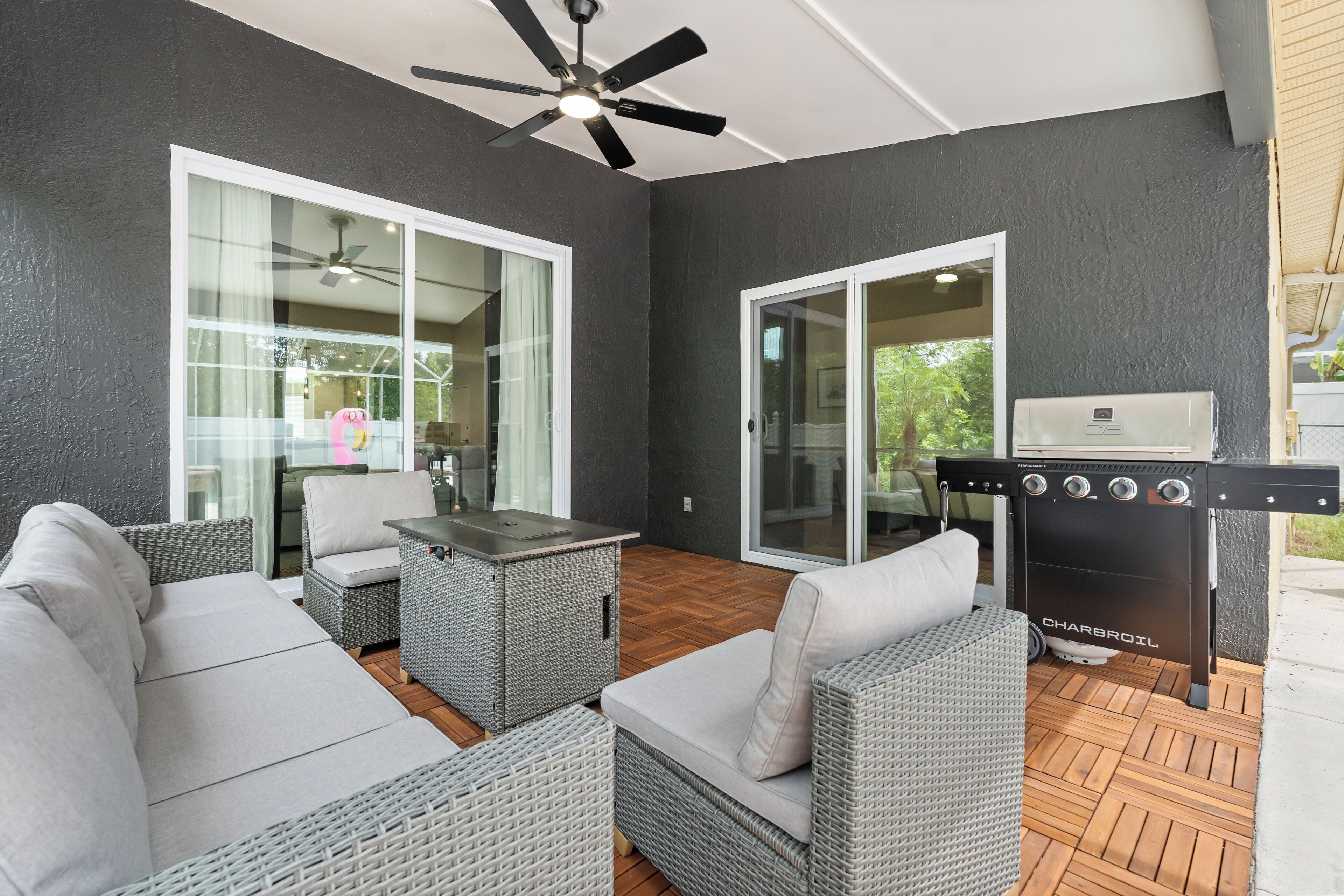 An outdoor patio with wicker furniture, a ceiling fan, and a barbecue grill.