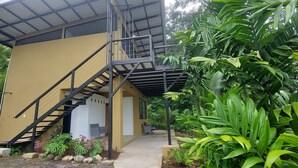 A two-story building with a staircase leading to a covered outdoor area. - 2 bedroom home with ocean and jungle views in Pavones. Views of the point break. (Pavones)