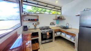 A compact kitchen with a stove, oven, sink, and a refrigerator. - 2 bedroom home with ocean and jungle views in Pavones. Views of the point break. (Pavones)