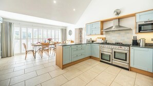 Une cuisine moderne dotée d’un îlot central, d’appareils électroménagers en acier inoxydable et de meubles de couleur bleu clair.