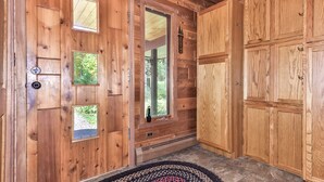 A wooden cabin interior with a large wooden door, a window, and a welcome sign. - Quite Lakefront Home on UTV/ATV/Snowmobile trails.  Dog Friendly! (Mercer)