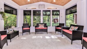 A sunroom with wicker furniture, large windows, and a wooden ceiling. - Quite Lakefront Home on UTV/ATV/Snowmobile trails.  Dog Friendly! (Mercer)