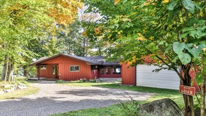 A red cabin with a gravel driveway and a mailbox labeled "MERCER 6814 N." - Quite Lakefront Home on UTV/ATV/Snowmobile trails.  Dog Friendly! (Mercer)