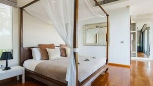 Una cama con dosel, una mesita de noche y un espejo en la pared.