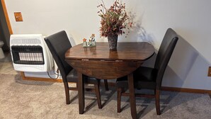 Une table à manger avec quatre chaises, une plante en pot et un objet décoratif posé sur la table.