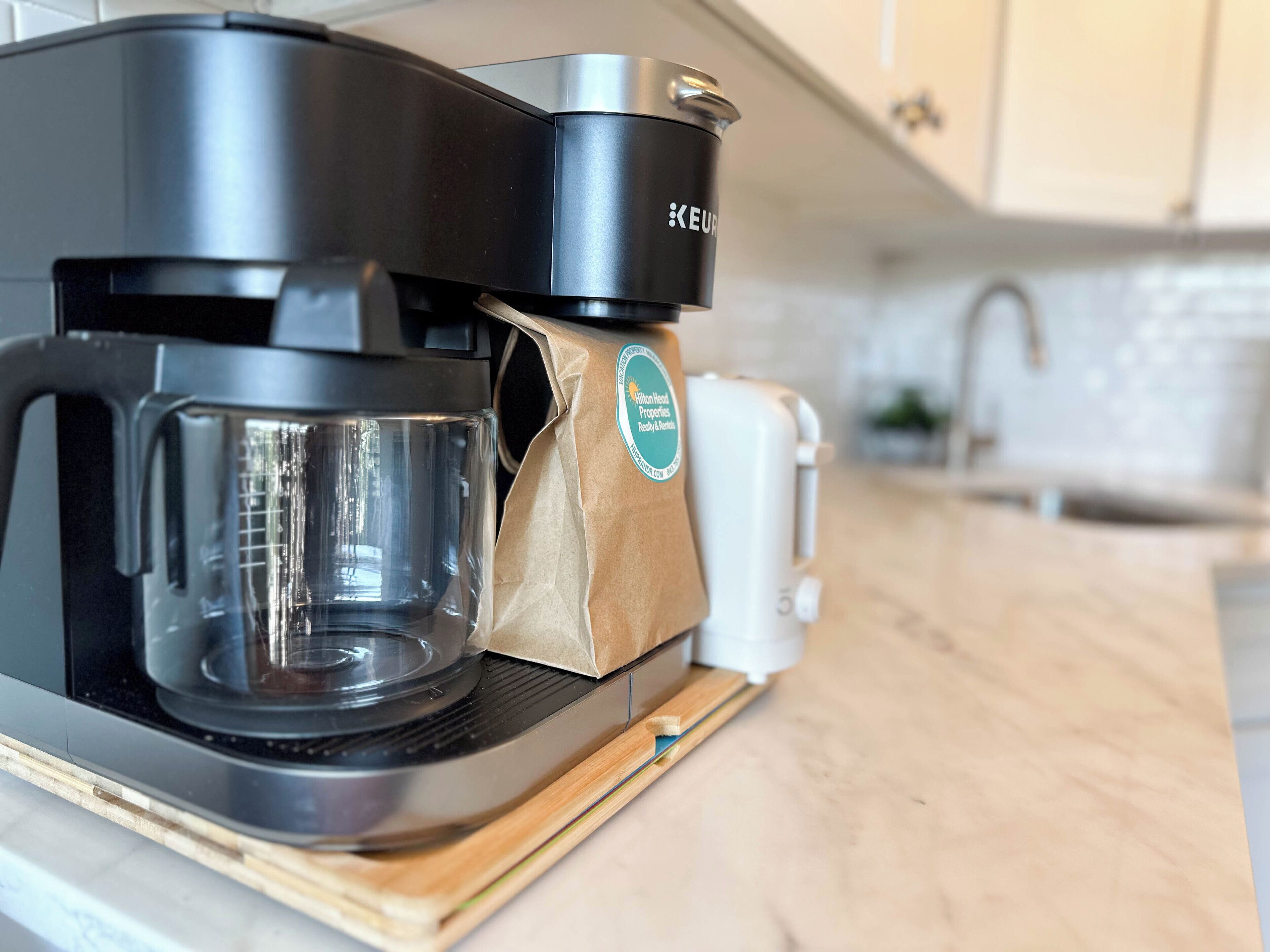 A Keurig coffee maker with a paper bag on the drip tray.
