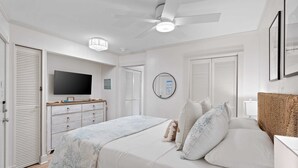 A bedroom with a bed, a television, a ceiling fan, and a dresser. - Beachfront Couples Coastal Getaway
Oceanview I Pool I Balcony  AC
Parking I WIFI (Hilton Head Island)