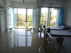 A room with two beds, a table, and a chair. - Mangkonlay Hostel Krabi (Krabi)