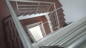 A staircase with metal railings and a view of a room with a door and a window.