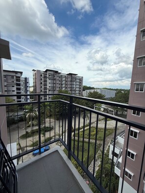 A balcony with a view of adjacent buildings and a road.