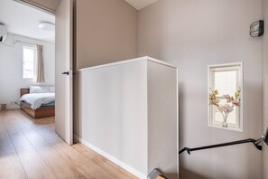 A room with a bed, a white partition, a window with flowers, and a black handrail. - Max. 12 people OK! Less than 15 minutes walk to the station and the sea! A house in a good location in Kamakura! (鎌倉市大町)