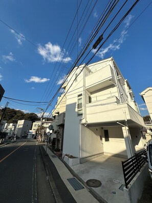 A multi-story residential building with a flat facade, a visible balcony, and a street in front. - Max. 12 people OK! Less than 15 minutes walk to the station and the sea! A house in a good location in Kamakura! (鎌倉市大町)