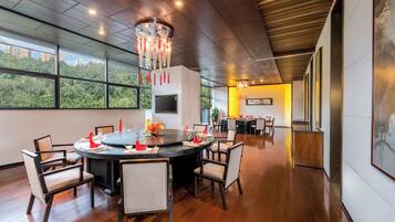 A modern dining area with a round table, chairs, and a chandelier.