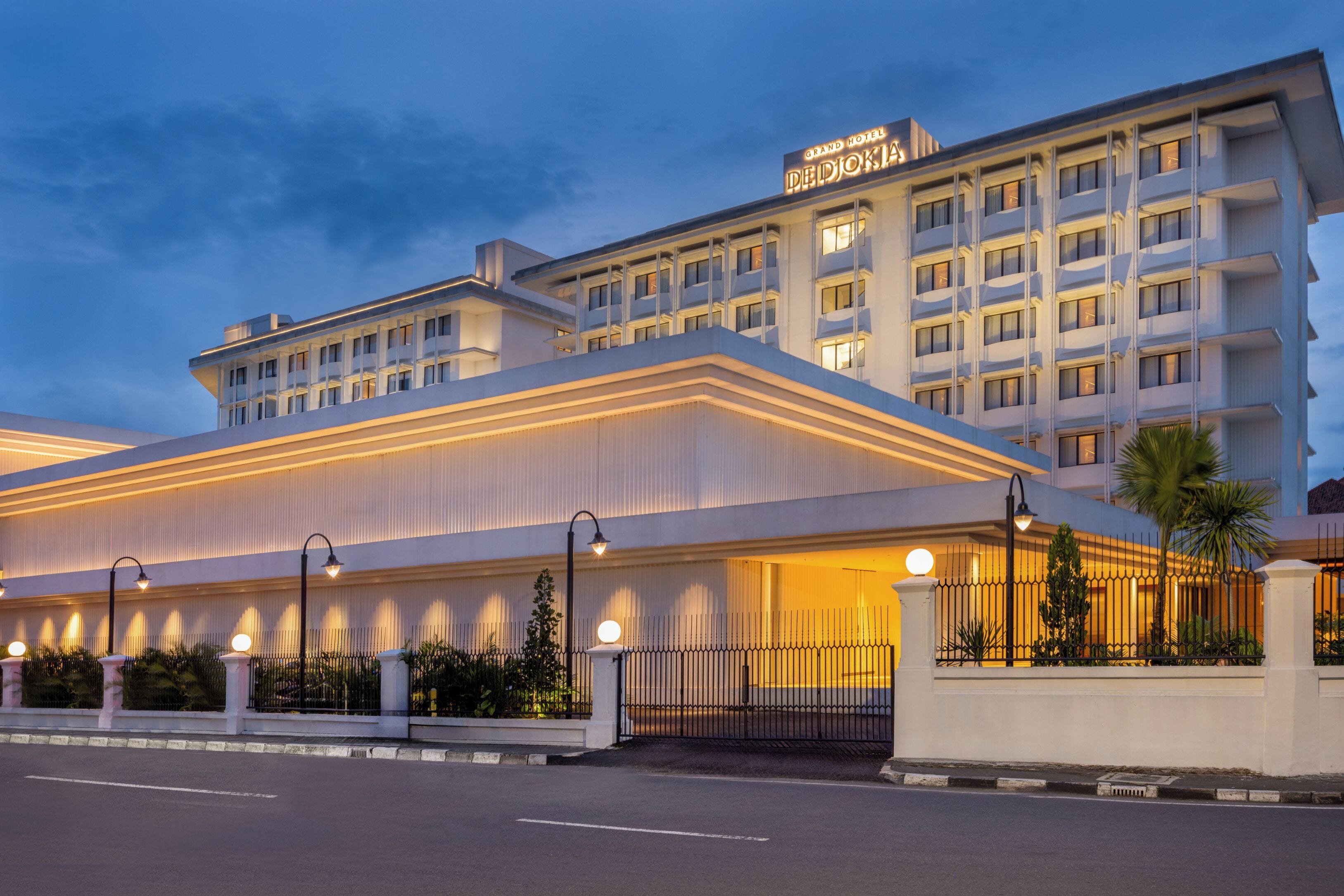 A large hotel with a prominent sign, multiple floors, and a well-lit entrance.