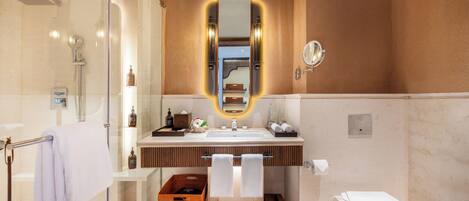 A modern bathroom with a glass shower enclosure, a vanity with a mirror, and a toilet.