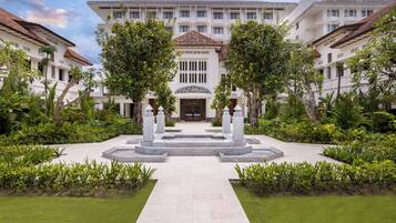 A hotel with a central courtyard, surrounded by lush greenery and a tiled walkway.