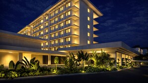 A multi-story hotel with a modern design, featuring balconies on each floor and a well-lit entrance area. - Grand Hotel De Djokja (Yogyakarta)