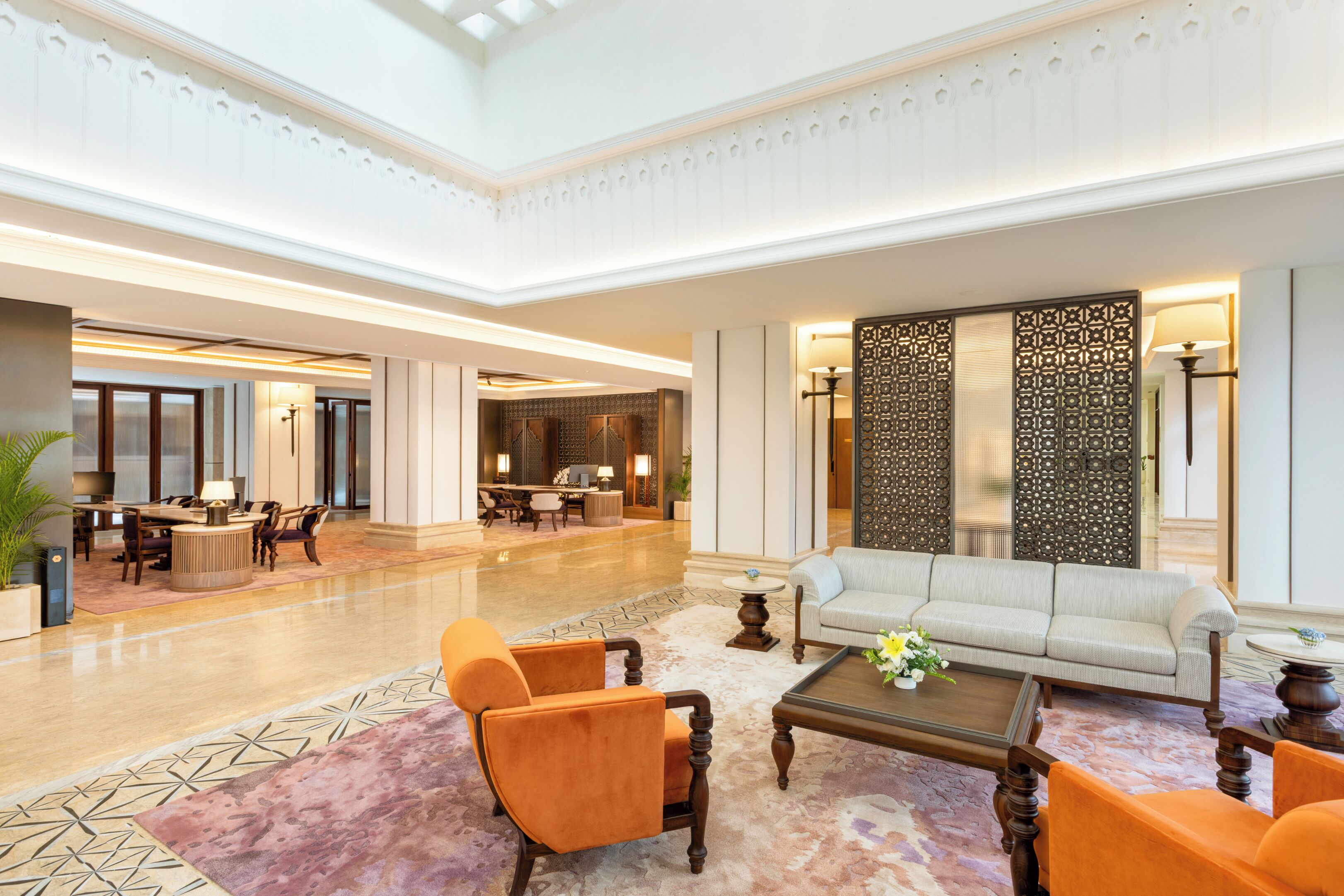 A spacious lobby with a seating area, a dining setup, and a decorative wall.