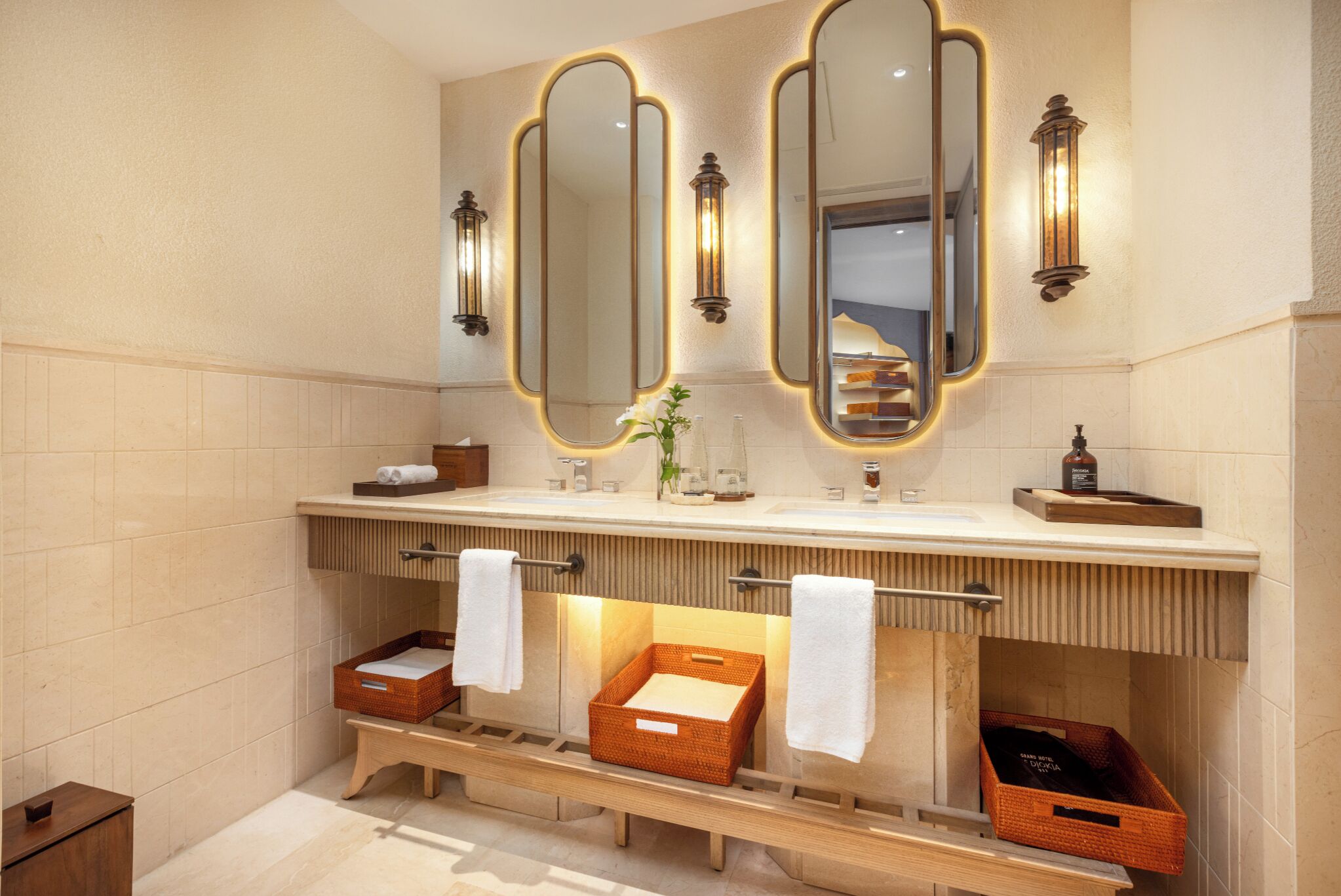 Une salle de bain avec trois miroirs, un meuble-lavabo et deux porte-serviettes.