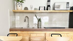 A modern kitchen with a wooden countertop, stainless steel sink, and a built-in microwave. - Local atmosphere great location 2 bedroom, Fast WiFi Ideal for long stays. (Cancún)