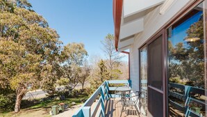 A balcony with a view of trees and a road. - Alpha Centauri - 8/39 Gippsland Street (Jindabyne)