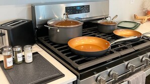 Eine Küche mit Herd, Töpfen, Pfannen und Gewürzgläsern.