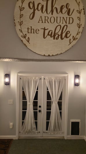 A room with a sign above a double door that reads "gather around the table."