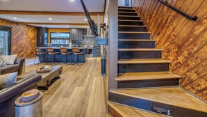 Un intérieur moderne avec un escalier en bois, un coin bar et un espace salon.
