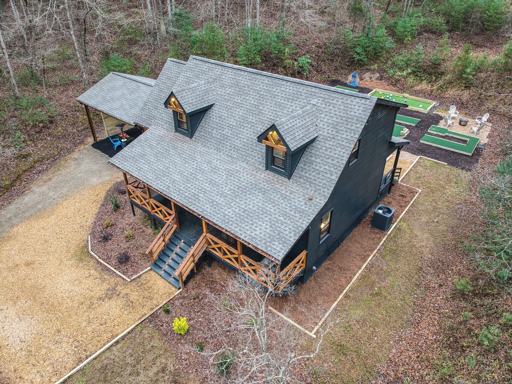 A cabin with a steep roof, a porch with wooden railings, and a small deck area.