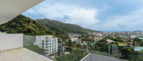 A balcony with a view of a hillside and a town below.