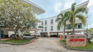 A modern building with a reception area, parking, and a tree. - Sea View 2BR Condo Prime Location C236 (Karon)