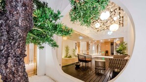 A modern interior with a circular viewing window, wooden flooring, and a seating area with a sofa and chairs. - Wangting Jinxiu Hotel (Shanghai)