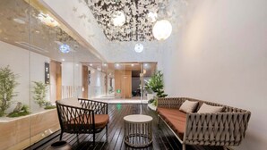 A modern lobby with a wooden floor, a round table, and seating areas. - Wangting Jinxiu Hotel (Shanghai)