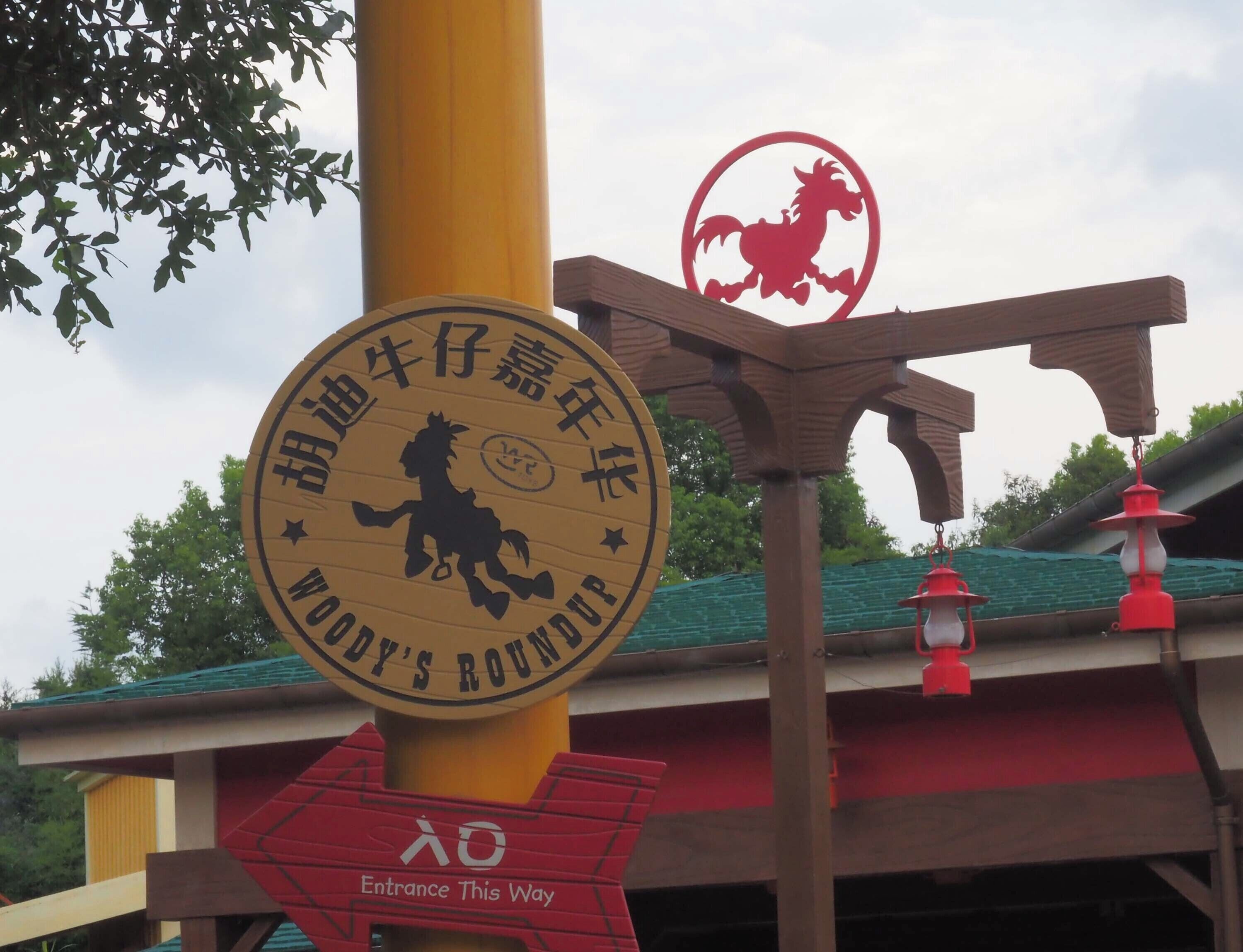 A sign with a horse silhouette and text, a red entrance sign, and a red lantern.